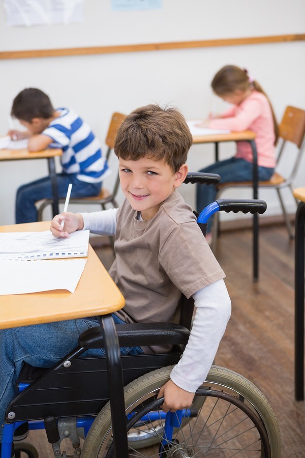 boy in wheelchair at desk in classroom