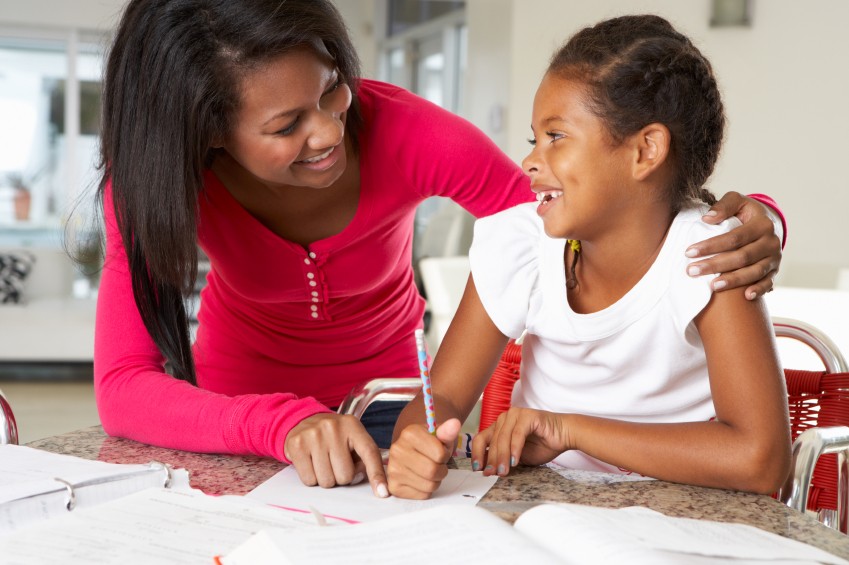 teacher works with young girl in classroom