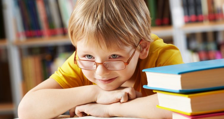 young boy with glasses in library