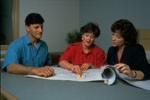 adults reading to young child