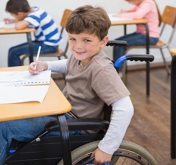 picture of school boy at desk in wheelchair