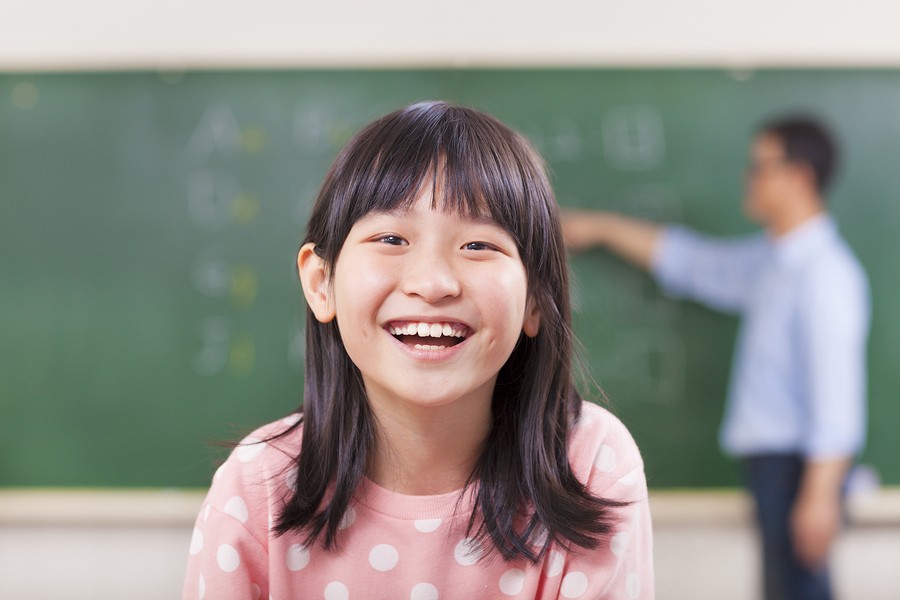 girl in front of blackboard with math problems