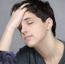 teen boy with hand on head eyes closed