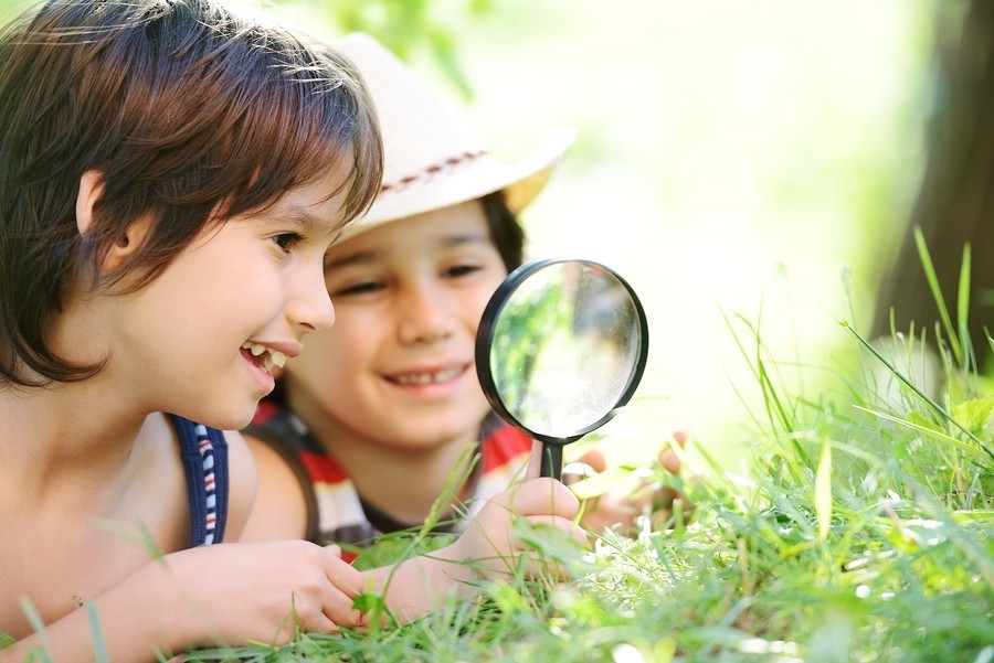 kids playing outside with magnifiying glass