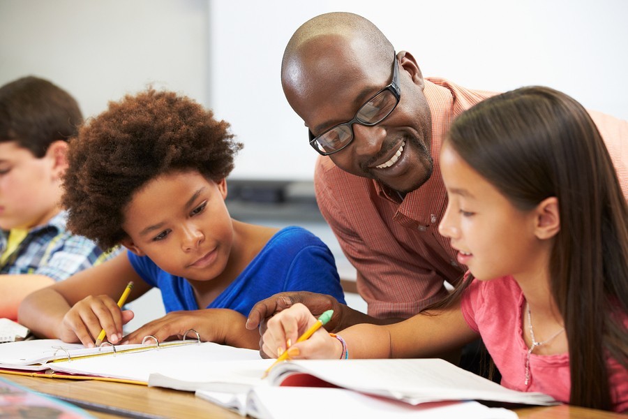 girls learning to read with teacher