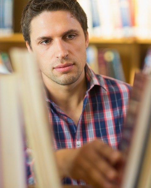 image of man doing research in library stacks