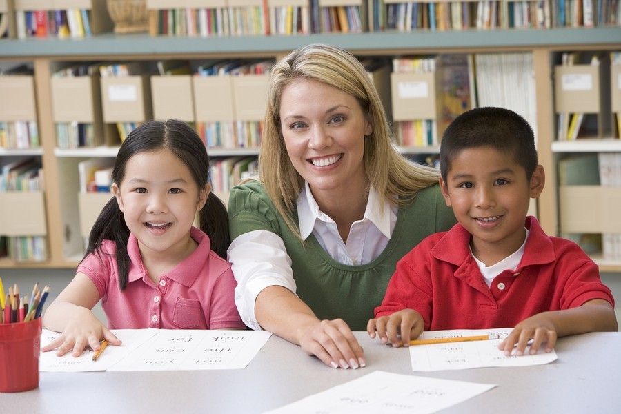 image of boy and girl with teacher in school library