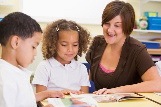 teacher reading with boy and girl student