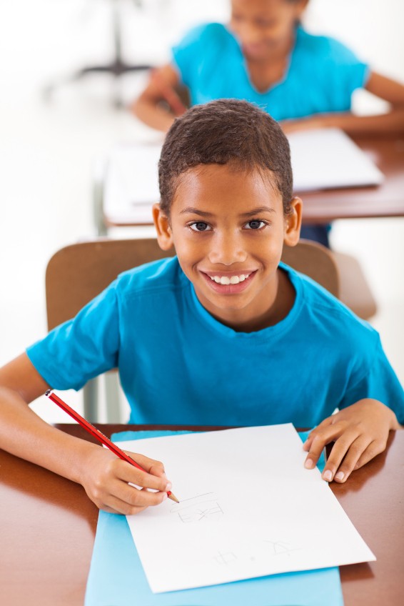 image of young boy student writing in class