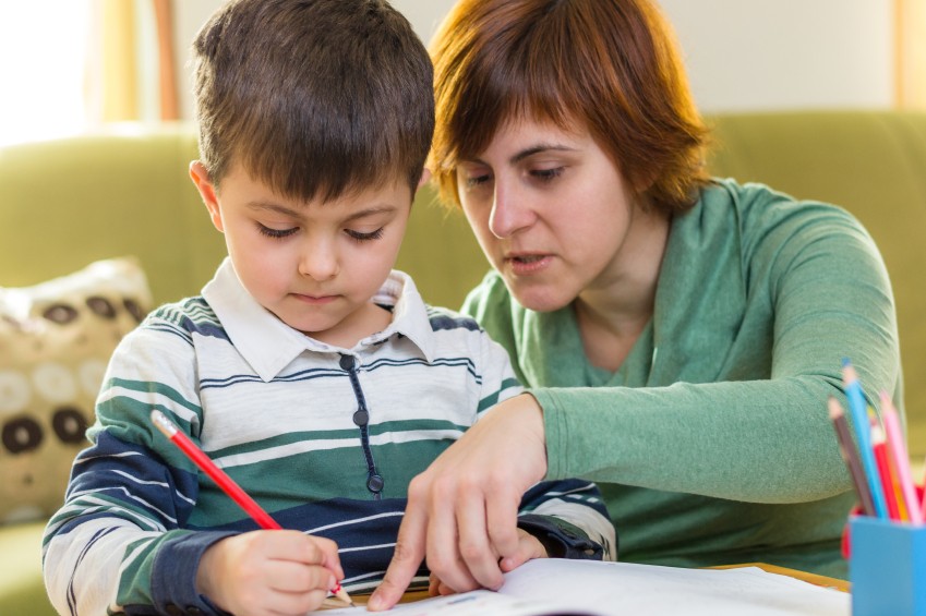 boy struggling with homework with mom