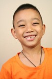 boy in orange shirt smiles