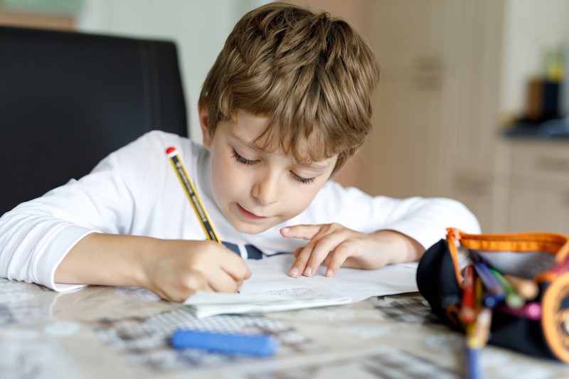 image of boy writing in class