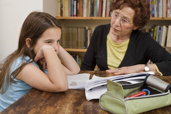 evaluator and young girl taking reading test