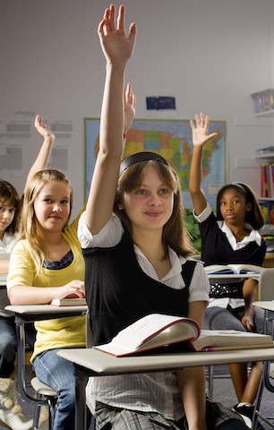 girl in class with hand raised