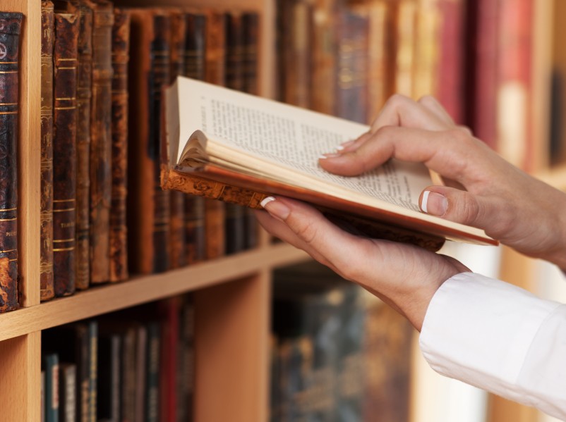 hands holding book in library