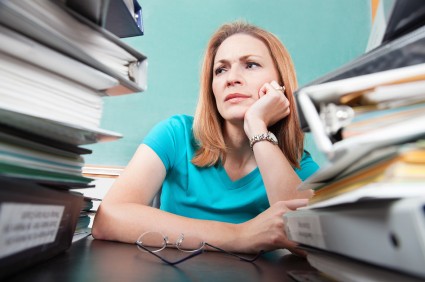 woman with mountains of unfiled paperwork