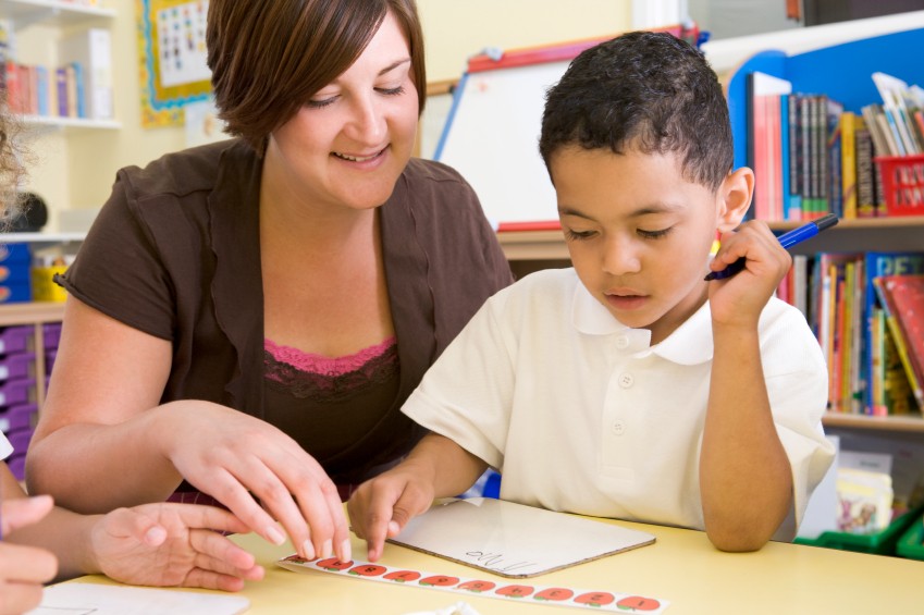 teacher and boy working together in school