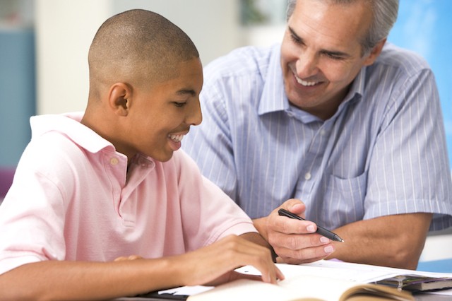 image of teen boy reading with tutor or teacher