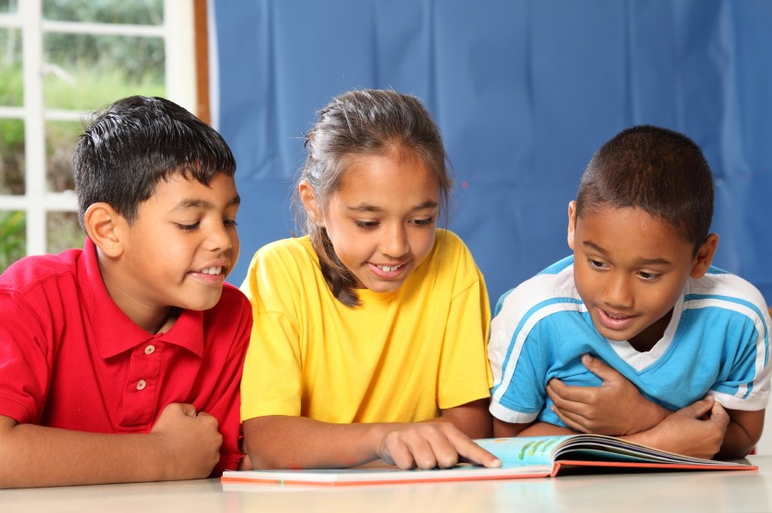 three school children reading books