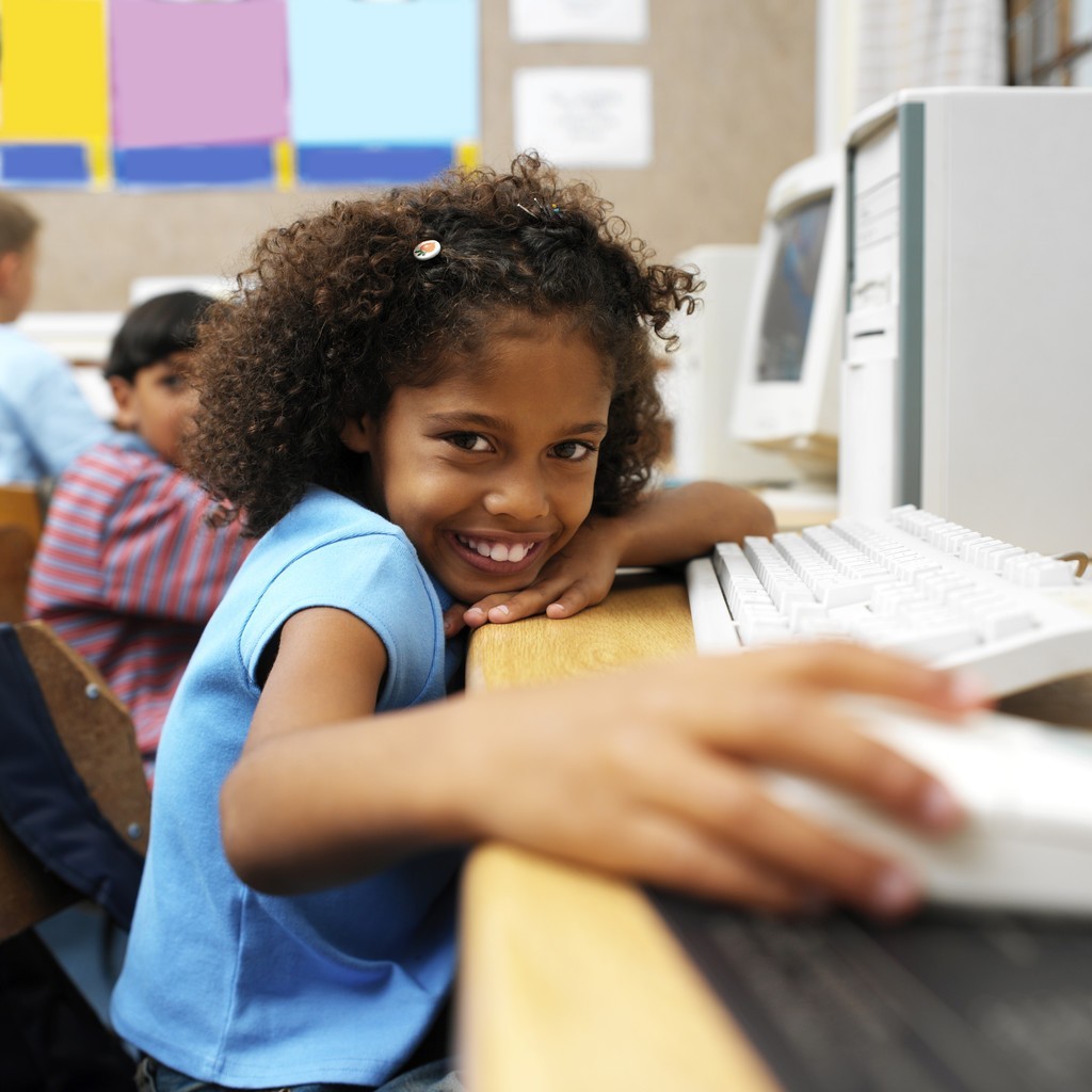 young girl at the computer smiling